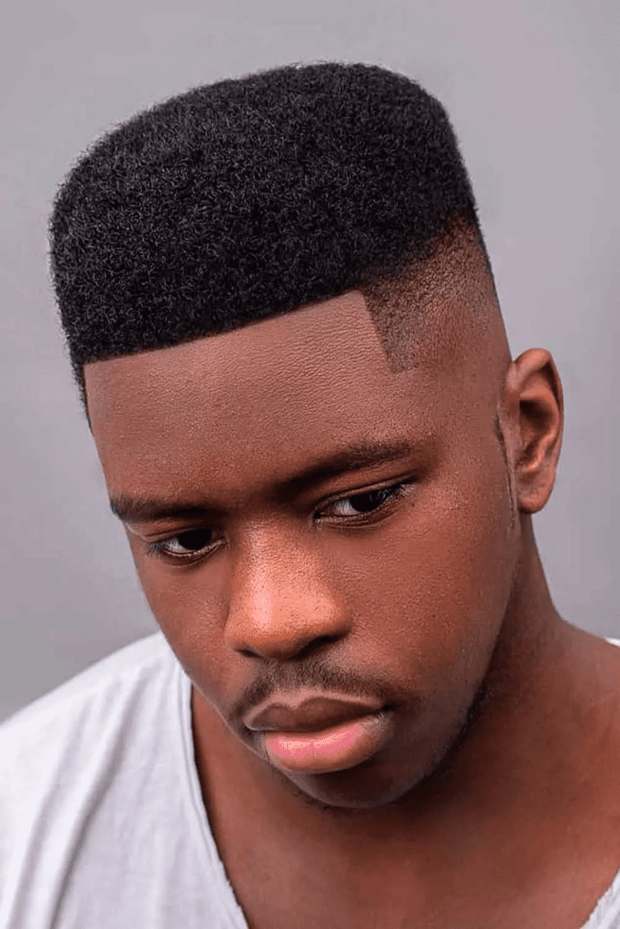 Flat top haircut with burst fade on black man showing precise angles and clean lines