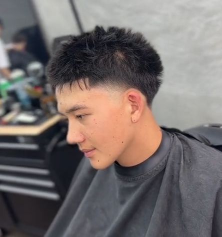 Professional barber trimming a client’s thinning hair with a 13 guard clipper, demonstrating the benefits of a short, neat haircut.