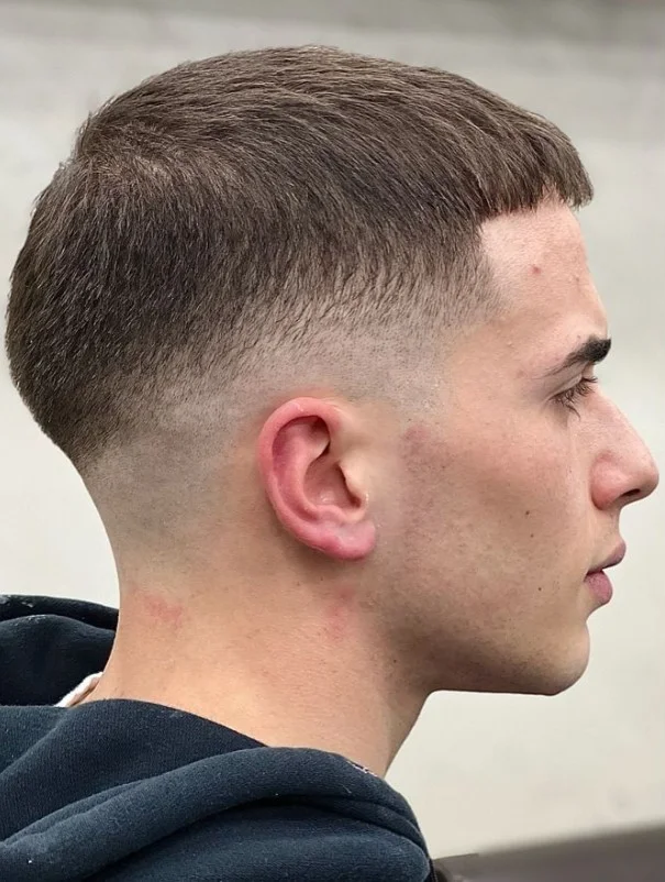 Man with a 7 guard buzz cut and low fade, showcasing a clean, professional short hairstyle for straight hair.