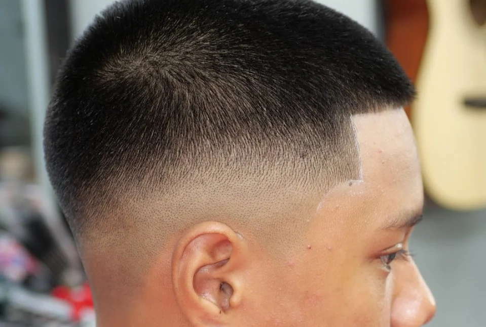 Close-up of a 7 guard buzz cut with high fade, showing a bold, edgy short haircut for men.