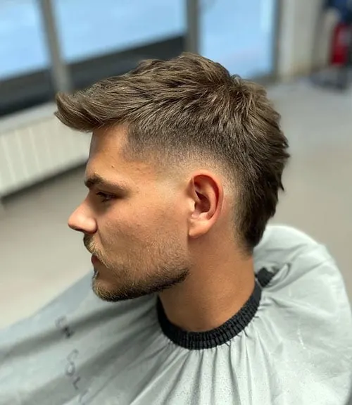 A men in Mohawk fade cutting