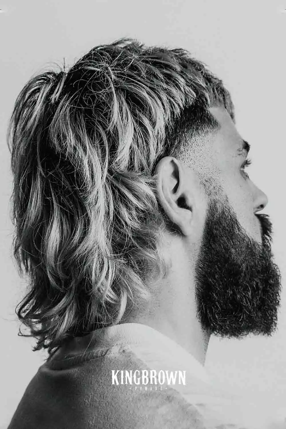Modern burst fade mullet with long hair, featuring clean burst fade on the sides and longer hair at the back, edgy burst fade long hair style.