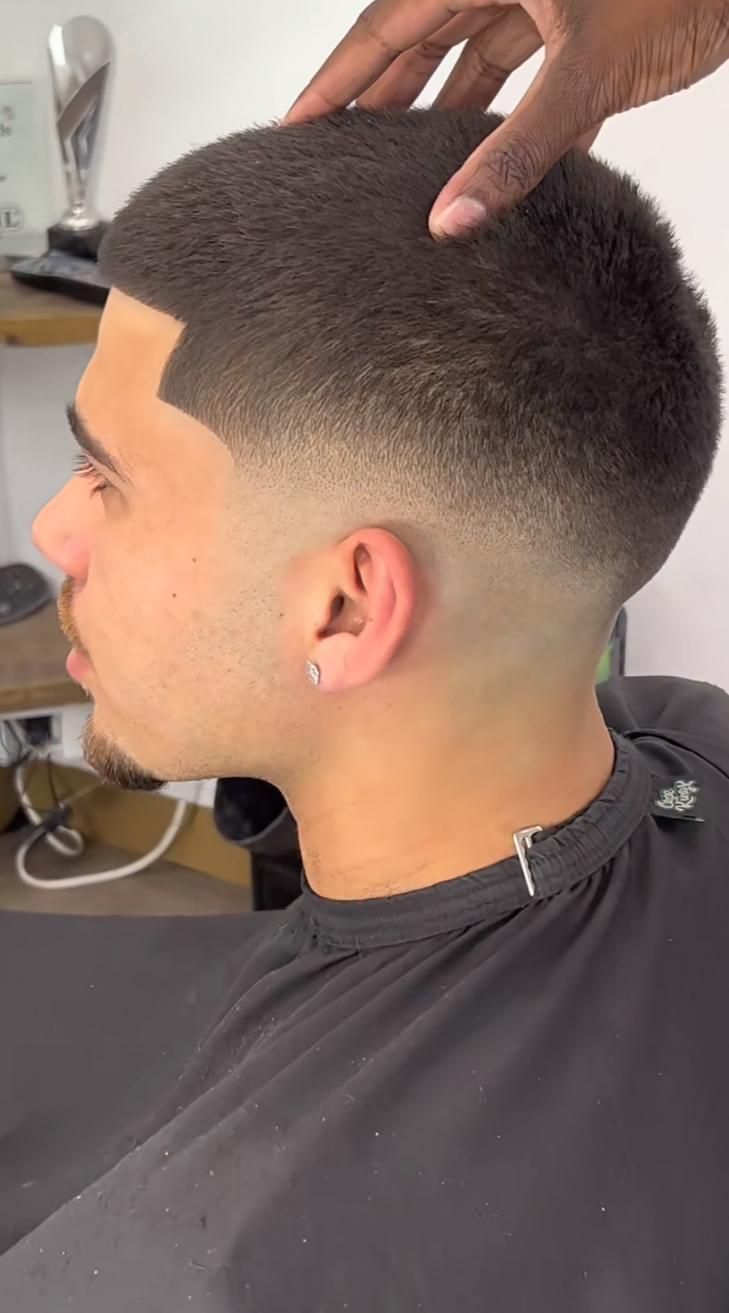 Barber using clippers for a 10 guard buzz cut, demonstrating expert men’s grooming techniques for a clean look.