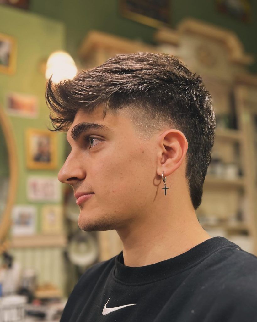 Man with modern mullet haircut showcasing bold timeless hairstyle.