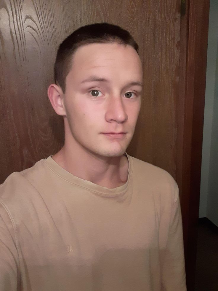 Professional barber using electric clippers to craft a precise buzz cut, ideal for clients with high foreheads or receding hairlines.