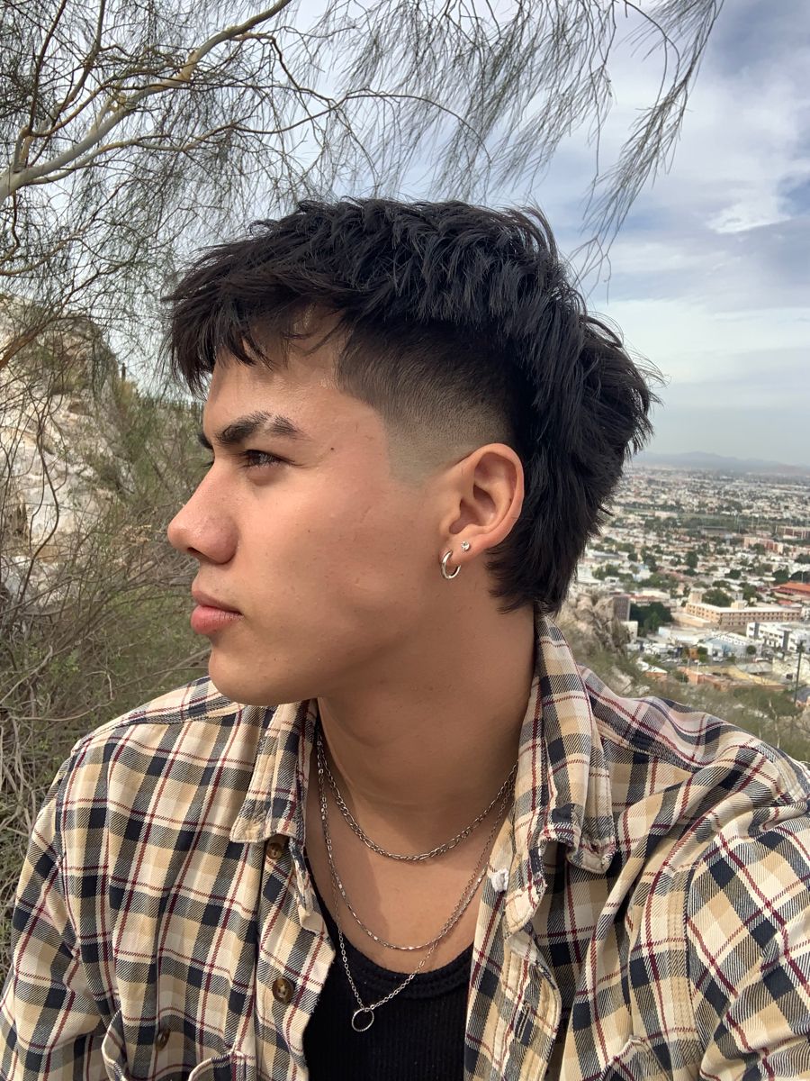 Close-up of a burst fade mullet on curly hair, featuring a sharp neck taper and textured back, modern mullet style.