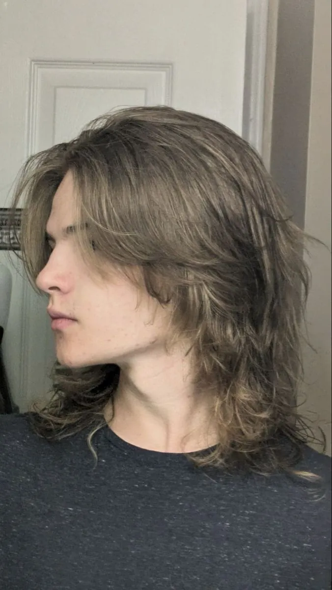 Man with a modern shaggy mullet haircut featuring textured layers and messy volume