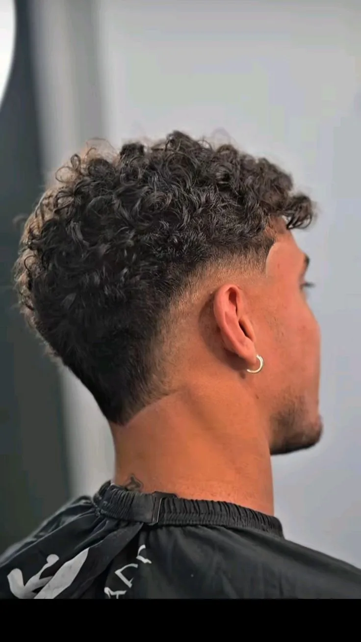 Stylish man with top wavy mullet style featuring loose waves and tapered back for trends